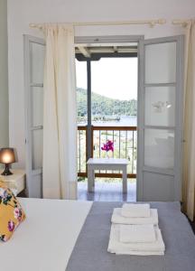 a bedroom with a bed with a view of a balcony at Skalopati Studios & Villa in Panormos Skopelos