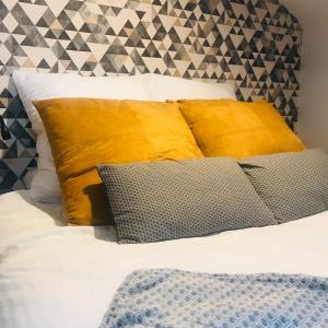 a bed with yellow pillows and white sheets at La Galerie, Et Pop Et Chic ! in Poitiers