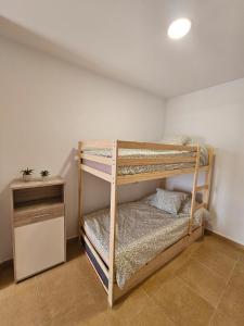 a room with two bunk beds and a night stand at apartamentos terraza Chiclana centro ciudad in Chiclana de la Frontera