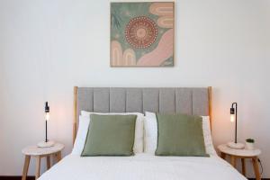 a bedroom with a bed with two side tables at Hillarys Hideaway in Perth