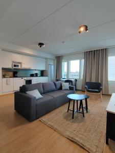 オウルにあるForenom Serviced Apartments Oulu Lekatieのソファとテーブルのあるリビングルーム