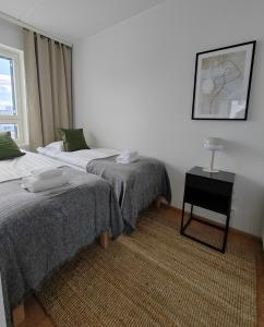 オウルにあるForenom Serviced Apartments Oulu Lekatieのベッドルーム1室(ベッド2台、ランプ付きテーブル付)