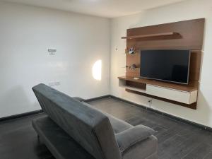 a living room with a couch and a flat screen tv at Casa do Naldo in Brasília