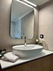 a bathroom with a sink and a large mirror at R&G luxury accommodation Varkiza in Vari