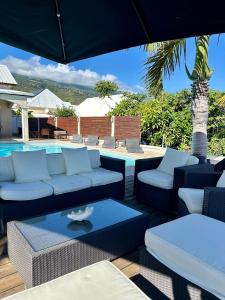 圣勒VILLA POINTE DES CHATEAUX VUE IMPRENABLE的一个带沙发和椅子的庭院和一个游泳池