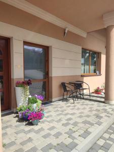 a patio with two chairs and a table and flowers at Pokój gościnny w Twardorzeczce in Plebańska +2 photos