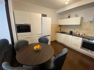een keuken met een tafel, stoelen en een koelkast bij Apartamentai prie Kalnų parko in Vilnius