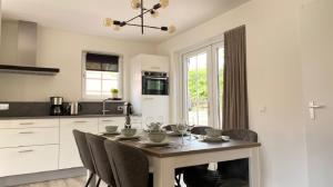a kitchen with a table and chairs in a kitchen at The Pimpelmees in Hoge-Hexel