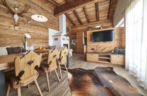 a dining room with a table and chairs and a television at Panorama Chalets in Saalbach-Hinterglemm