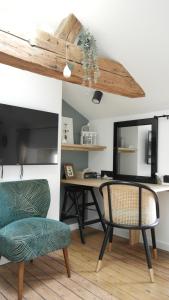 a room with a desk and two chairs and a mirror at La Curiosité, Et Pop Et Chic ! in Poitiers