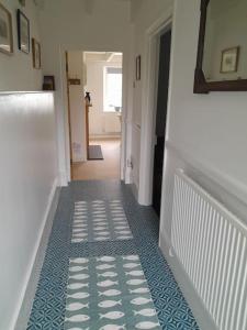 a hallway with a blue and white tile floor at The Captain's House Charlestown St Austell in Charlestown