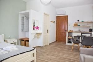 a room with a bed and a desk and a kitchen at Skalopati Studios & Villa in Panormos Skopelos