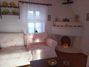 a living room with a couch and a fireplace at Skopelos Mortero Cottage in Panormos Skopelos +25 photos