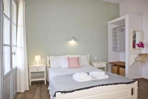 a bedroom with a white bed with towels on it at Skalopati Studios & Villa in Panormos Skopelos