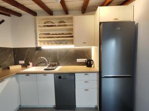 a kitchen with a stainless steel refrigerator and white cabinets at Skopelos Mortero Cottage in Panormos Skopelos