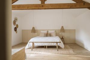 a bedroom with a white bed and a wooden ceiling at L'Annexe Singulière in Maillé