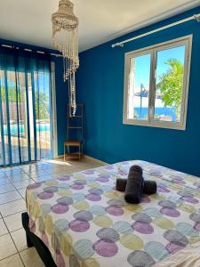 圣勒VILLA POINTE DES CHATEAUX VUE IMPRENABLE的卧室里有一张床，墙壁是蓝色的