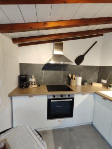 a kitchen with white cabinets and a stove top oven at Skopelos Mortero Cottage in Panormos Skopelos