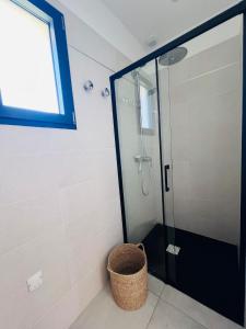 a bathroom with a glass shower with a basket at Villa KAÏS in Lecci +4 photos