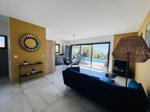 a living room with a black couch and a mirror at Villa KAÏS in Lecci