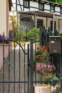 a black wrought iron fence with flowers and plants at Apartament Londyn in Łagów