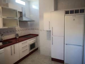 a kitchen with white cabinets and a white refrigerator at Villa Izael AT-BA-00317 in Talavera la Real