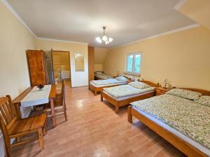 a room with three beds and a table and chairs at U Gienka Pod Lasem in Święta Katarzyna