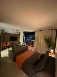 ein Wohnzimmer mit einem Bett und einer Couch in der Unterkunft Itacaré Aluguel in Itacaré