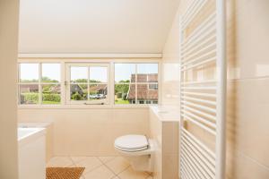 a white bathroom with a toilet and a window at De Bosuil in Hoge-Hexel +87 photos