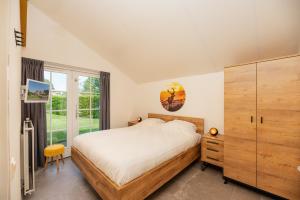a bedroom with a bed and a large window at De Bosuil in Hoge-Hexel