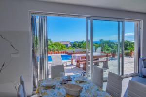 comedor con mesa y vistas a un patio en Villa Joanna - hidden oasis with pool, gym & garrage, en Novalja