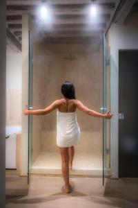 a woman in a white dress walking into a glass door at Cortona Resort & Spa - Villa Aurea in Cortona