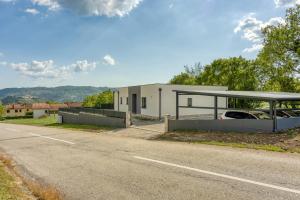 a building with a car parked next to a road at Holiday House Rhapsody in Buzet