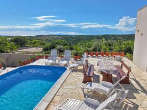 un complejo con piscina, sillas y vistas en Villa Joanna - hidden oasis with pool, gym & garrage, en Novalja