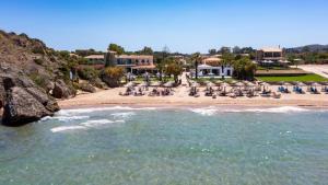 una vista di una spiaggia con sedie e un resort di Plaka Beach Resort a Vasilikós