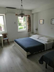 a bedroom with a large bed and two windows at Rooms Izola in Izola