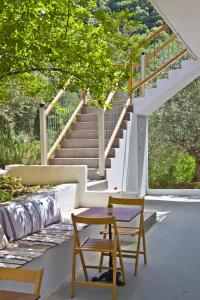 a table and a chair in front of a staircase at Skalopati Studios & Villa in Panormos Skopelos