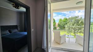 a bedroom with a bed and a view of a balcony at Apartments with Pool Casa Bianca in Matohanci