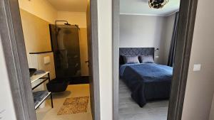 a bedroom with a blue bed and a bathroom at Apartments with Pool Casa Bianca in Matohanci +32 photos