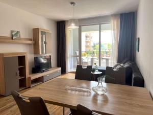 salon z drewnianym stołem oraz salon z kanapą w obiekcie Rosie's Cozy Bright Apartment Summer Paradise w miejscowości Sweti Konstantin i Sweta Elena +6 zdjęć