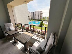 balkon ze stołem i widokiem na basen w obiekcie Rosie's Cozy Bright Apartment Summer Paradise w miejscowości Sweti Konstantin i Sweta Elena