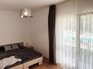 sypialnia z łóżkiem i dużym oknem w obiekcie Rosie's Cozy Bright Apartment Summer Paradise w miejscowości Sweti Konstantin i Sweta Elena