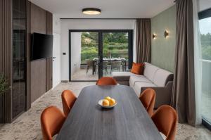 a living room with a wooden table and chairs at Luxury Villa David's - two heated pool in Podstrana