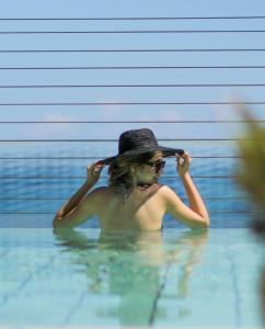 a woman wearing a hat in a swimming pool at Gefinor Rotana &ndash; Beirut in Beirut