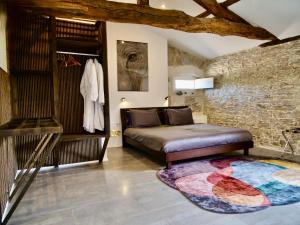 a bedroom with a bed and a stone wall at La Demeure de Saint Fiacre in Saint-Fiacre-sur-Maine