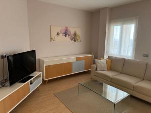 a living room with a couch and a flat screen tv at Cozy 2BR apartment next to Club Higueron Resort in Fuengirola