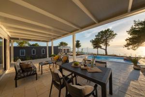 a patio with a table and chairs and a pool at Terra Park Phalaris in Novalja