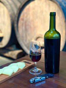 a glass of red wine next to a bottle of wine at Quarto dos Vinhos in São Roque +13 photos