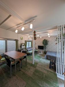 una sala de estar con una cama y una mesa en UMIBE Apartment, en Tokio