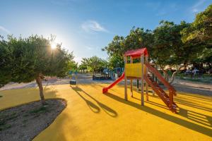 a playground with a slide in a park at Terra Park Phalaris in Novalja